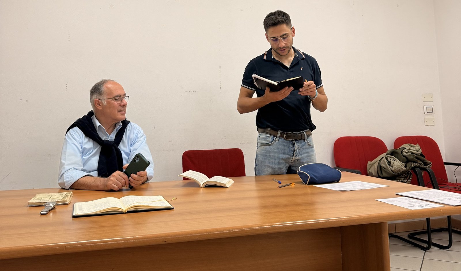 Il primo incontro di Scuola di Comunità della Comunità Pier Giorgio Frassati, 9 ottobre 2026: un relatore seduto al tavolo e un giovane in piedi che legge da un quaderno
