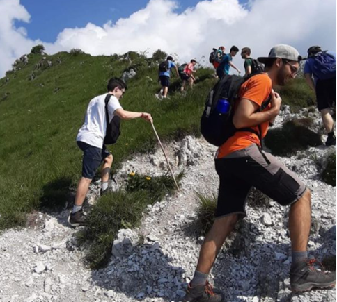 Giovani della Comunità salgono un sentiero di montagna durante la vacanza estiva