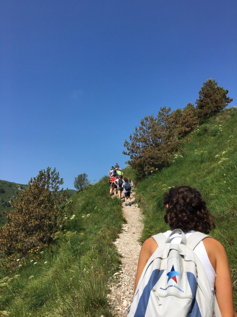 Una ragazza sale il sentiero verso la cima dietro al gruppo