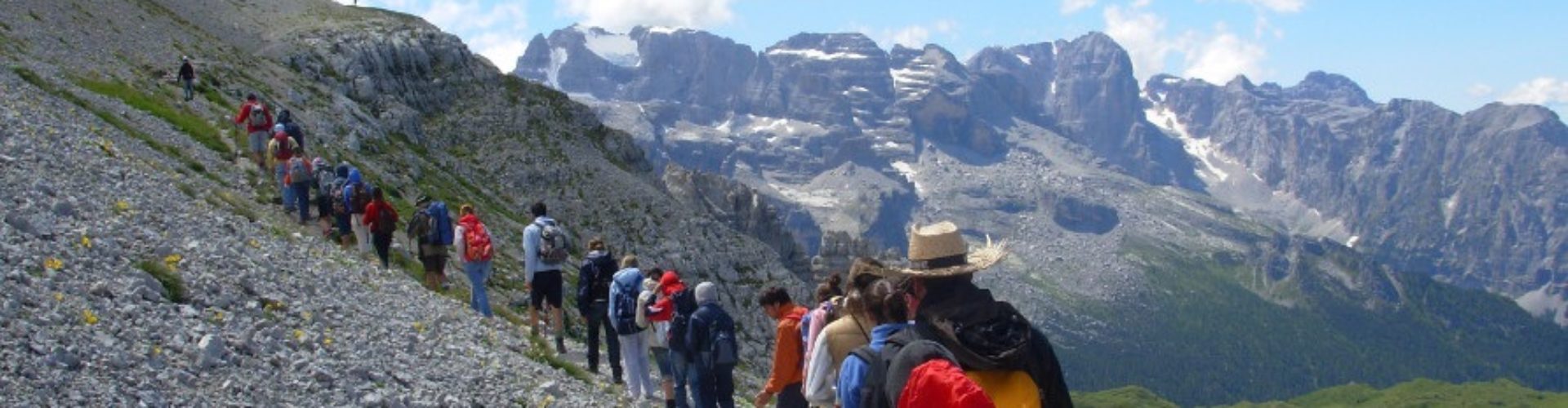 La Comunità in cammino in fila lungo un sentiero tra le Dolomiti